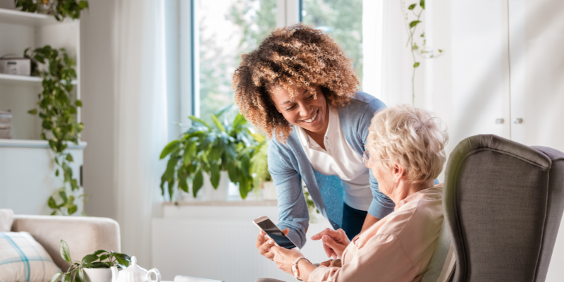 Woman showing an elderly lady something on a mobile phone