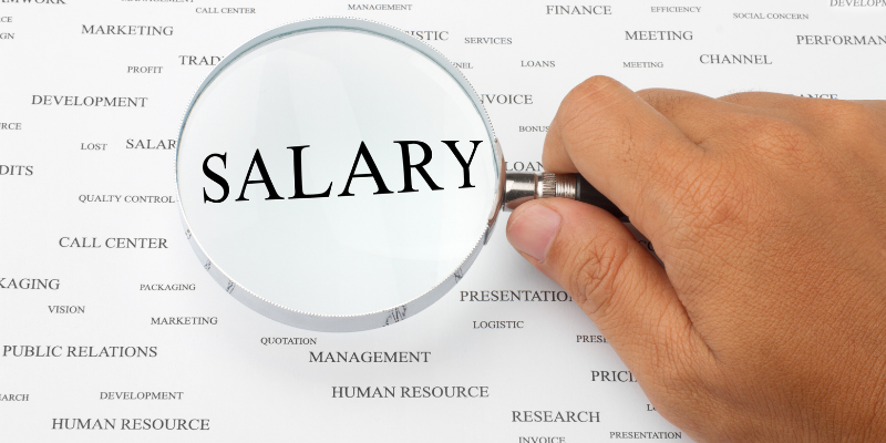 A magnifying glass magnifying the word "salary"