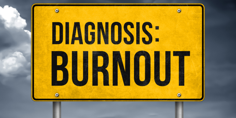 A signboard with the words "Diagnosis: Burnout" on it