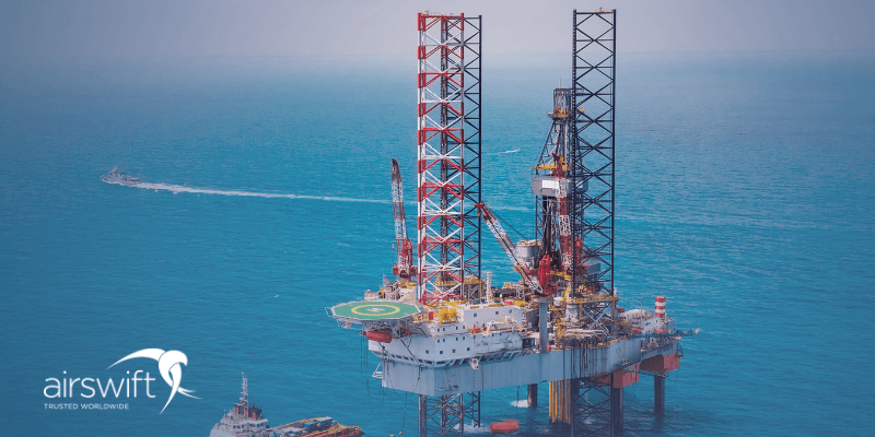 Offshore oil rig platform with cranes and support vessels in the ocean