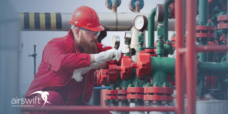 Oil rig worker adjusting machinery on an offshore platform