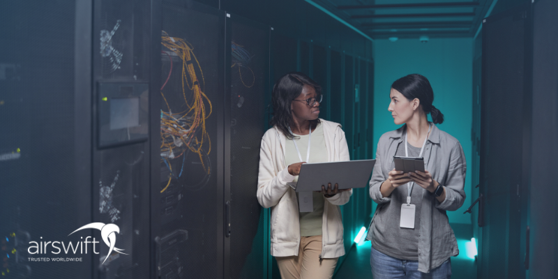 Two women engineers discussing server maintenance in a data center, highlighting diversity in tech roles