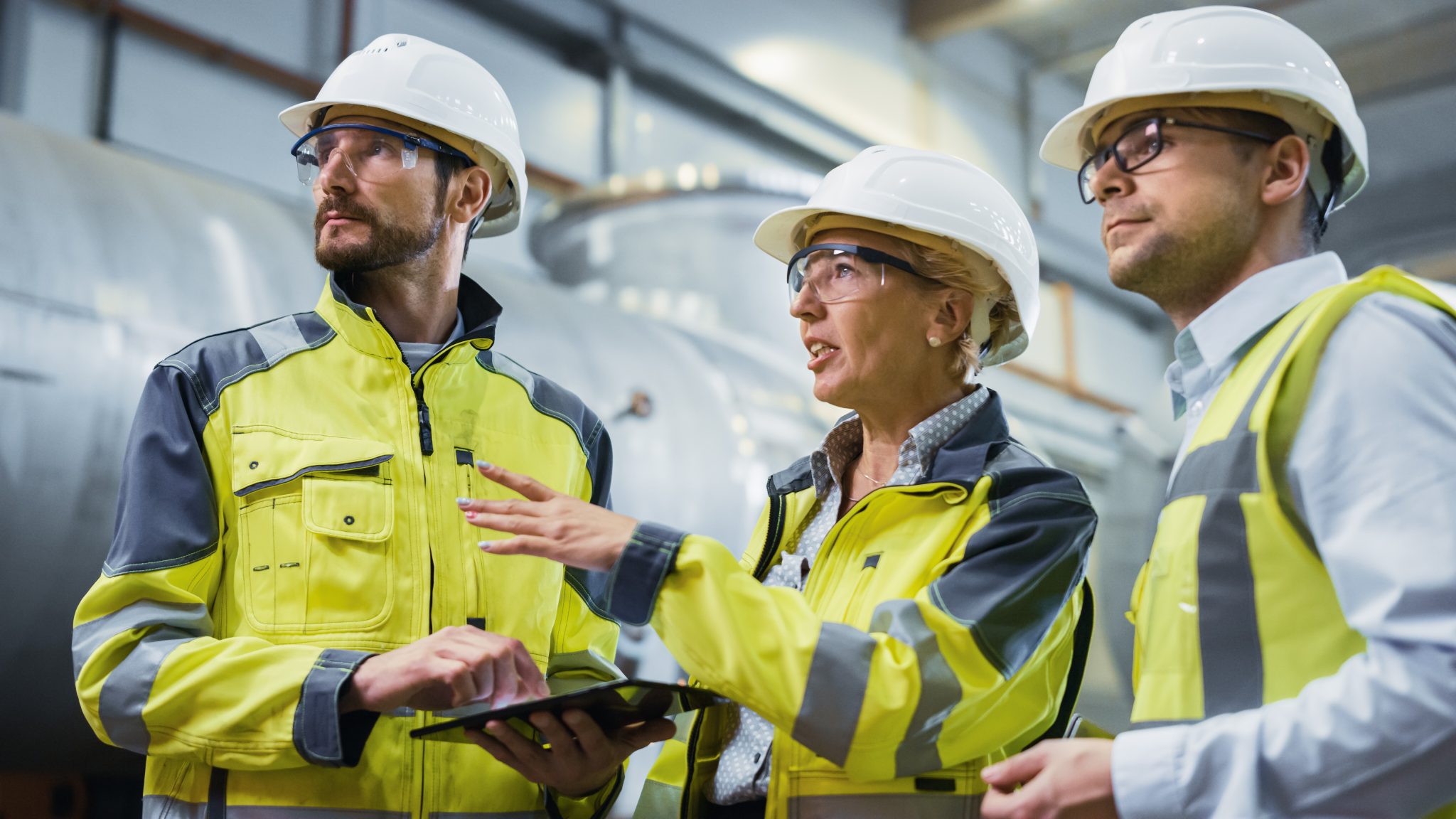 Three oil and gas workers in high vis and hard hats